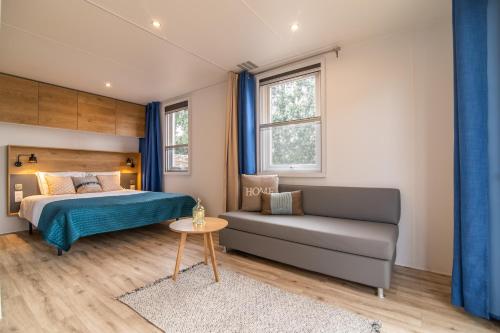 1 dormitorio con cama, sofá y mesa en Azor'Oasis, en Calhetas