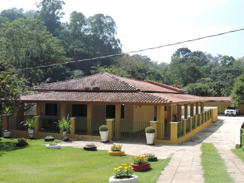 a house with a garden in front of it at Sítio Sebastião Pereira in Jambeiro