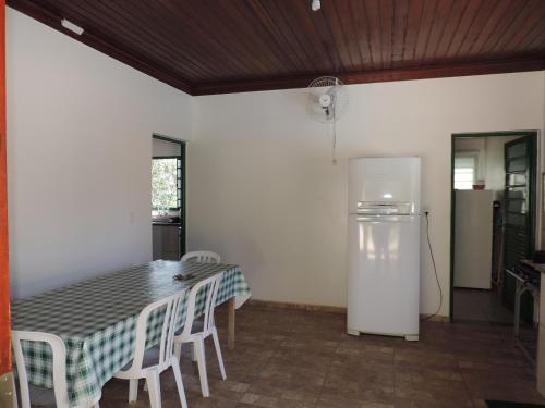 a kitchen with a table with chairs and a refrigerator at Sítio Sebastião Pereira in Jambeiro