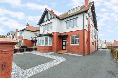 a large red brick house with a driveway at Cherry Property - Mulberry Suite in Blackpool
