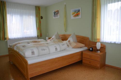 阿爾高地區旺根的住宿－Ferienwohnung Kitzelmann，一间卧室配有带白色枕头的木床
