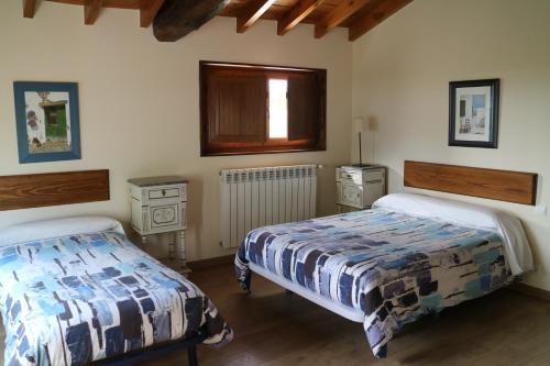 a bedroom with two beds and a window at Casa del Lago de Campoo in Orzales