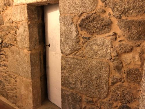 a stone wall with a door in a brick wall at Ecolagar O Barqueiro in Pantón