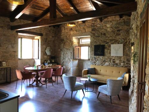 a living room with a couch and tables and chairs at Ecolagar O Barqueiro in Pantón