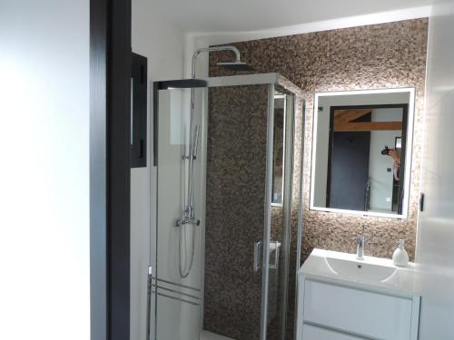 uma casa de banho com um chuveiro, um lavatório e um espelho. em A Muralha da Junqueira em Amarante