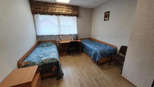 a hospital room with two beds and a desk at Pilnų namų bendruomenės apartamentai in Panara