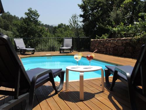 a patio with a table and two glasses of wine at A Muralha da Junqueira in Amarante
