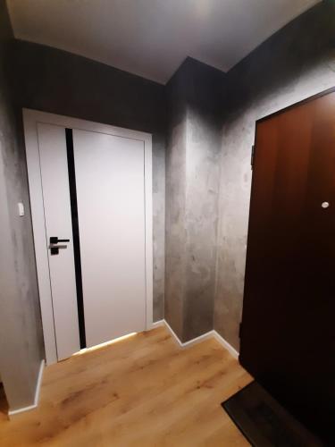 a room with a white door and a wooden floor at P&P Apartments in Kraków