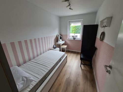 a small bedroom with a bed and a window at Große Ferienwohnung Nähe Flughafen Köln Bonn in Troisdorf