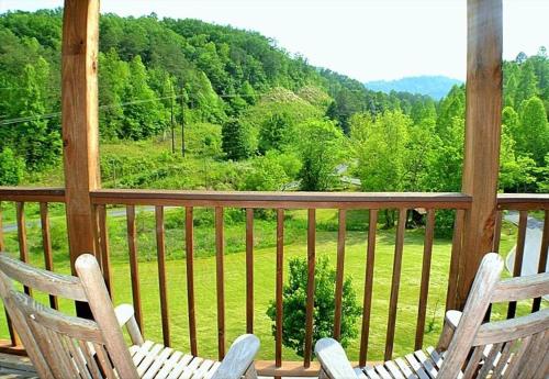 2 sillas en un porche con vistas al campo en The Ranch Cabin in Great Smoky Mountain, en Sevierville