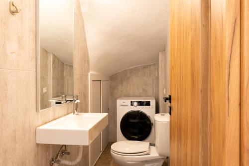 a bathroom with a white toilet and a sink at Valentina's Apartments in Agia Pelagia