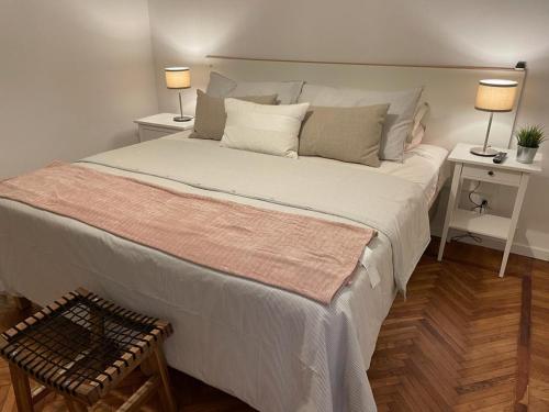 モデナにあるModena Estの大型ベッド1台、テーブル2台、ランプ2つが備わる客室です。