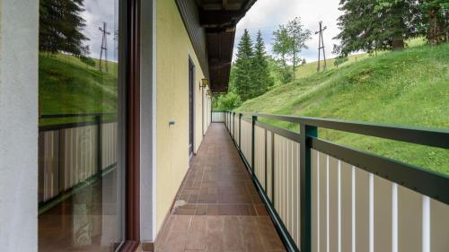 a balcony of a house with a view of a hill at Hotel Landhaus Ausswinkl in Russbach am Pass Gschütt