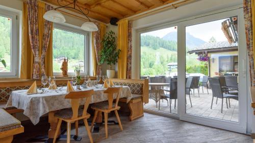 a restaurant with tables and chairs and a large window at Hotel Landhaus Ausswinkl in Russbach am Pass Gschütt