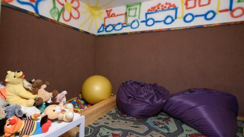 a childs bedroom with a purple bed with stuffed animals at Hotel Landhaus Ausswinkl in Russbach am Pass Gschütt