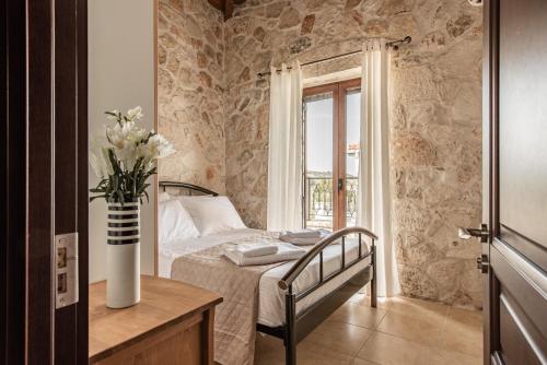 a bedroom with a bed and a vase of flowers at Murtini Stone Villa with Private Pool, by ZanteWize in Ayios Kirikos