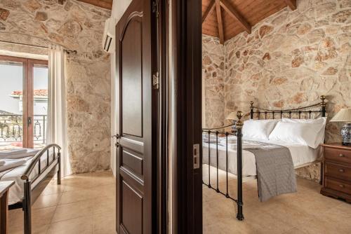 a bedroom with a bed in a room with stone walls at Murtini Stone Villa with Private Pool, by ZanteWize in Ayios Kirikos