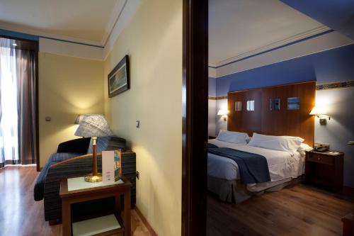Habitación de hotel con cama y mesa con luz en Suites Gran Via 44, en Granada
