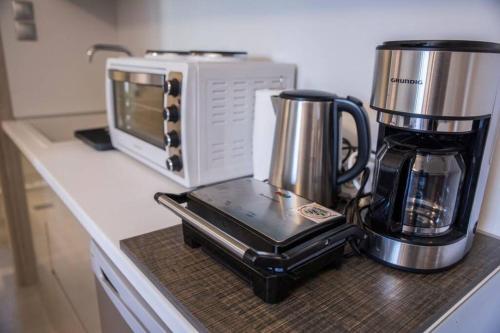 カランバカにあるMeteora Homeyのコーヒーメーカーと電子レンジを備えたキッチンカウンター