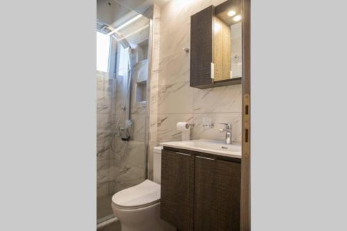 ein Badezimmer mit einem WC, einem Waschbecken und einem Spiegel in der Unterkunft Meteora Homey in Kalambaka