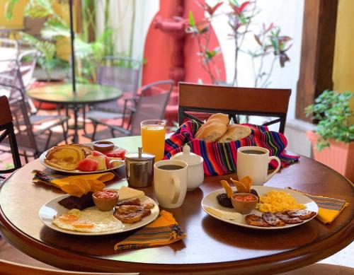 a table with plates of breakfast food on it at Hotel Posada San Miguel in Antigua Guatemala