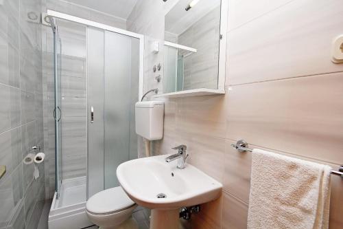 a bathroom with a sink and a toilet and a shower at Apartmani Batinović - Baška Voda in Baška Voda