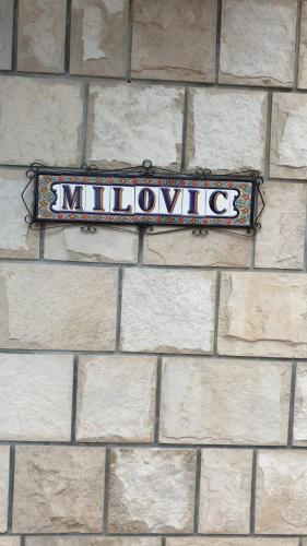 ein Schild an der Seite einer Ziegelmauer in der Unterkunft Milović apartmani in Igalo