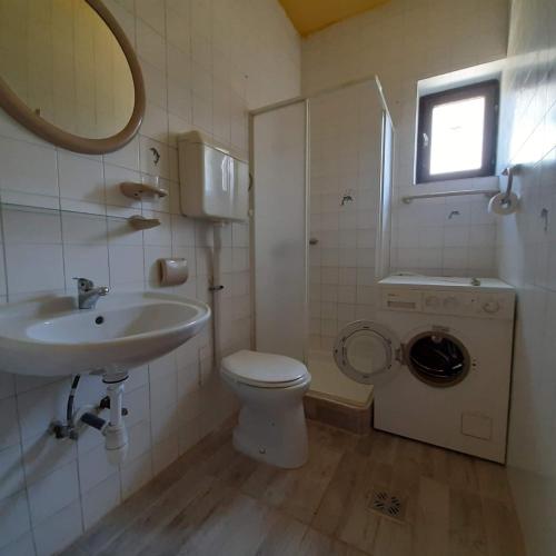 a bathroom with a sink and a toilet and a window at Tulman Villa in Balatonberény