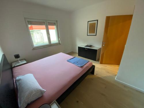 Un dormitorio con una gran cama rosa y una ventana en Apartment mit Parkblick, en Gratkorn