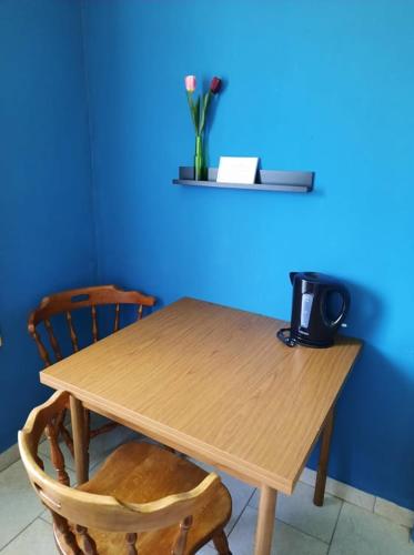 a wooden table with two chairs and a blue wall at Pension Horvath in Sankt Kanzian