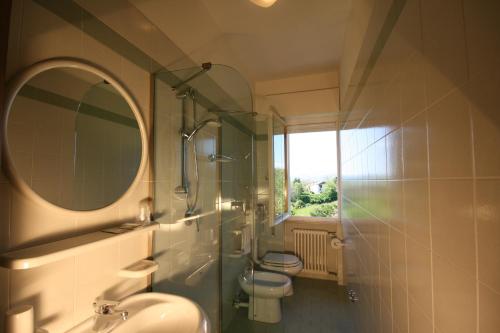 a bathroom with a sink and a toilet and a mirror at Albergo Centopini in Gemmano