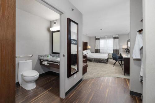 a hotel room with a toilet and a bedroom at Home Inn & Suites Yorkton in Yorkton