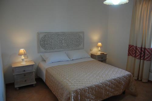 ポザーダにあるB&B Il Corbezzoloのベッドルーム1室(ベッド1台付)、2泊分のスタンド(ランプ付)