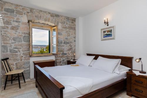 a bedroom with a large bed and a stone wall at Villa Lucija in Mimice