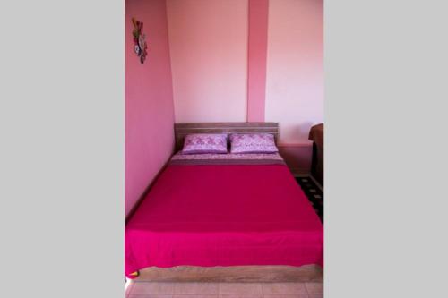 - un lit dans une chambre aux murs roses dans l'établissement Efi's Home, à Zakharo