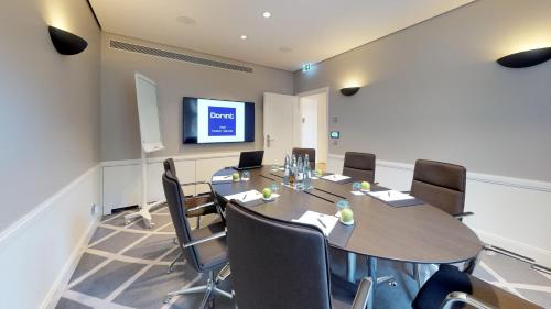 a meeting room with a long table and chairs at Dorint Hotel Frankfurt/Oberursel in Oberursel