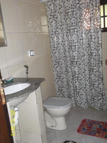 uma casa de banho com um WC e uma cortina de chuveiro em cantinho do sossego oficial em Caraguatatuba