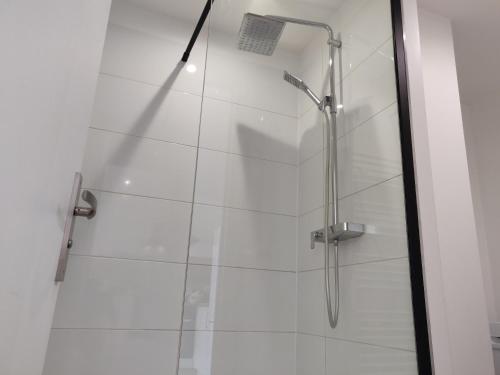 baño con cabina de ducha con puerta de cristal en Appart'HomeCity - Rouen Ile Lacroix Seine en Rouen