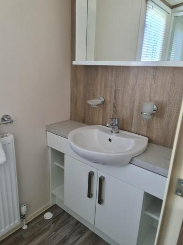 a bathroom with a white sink and a mirror at Mawgan Pads Trevella Crantock in Crantock