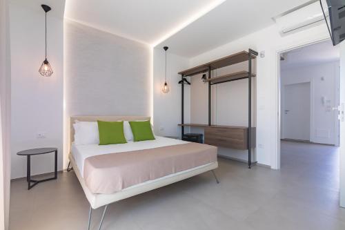 a bedroom with a bed with green pillows and a dresser at Horizon rooms in Torre Lapillo