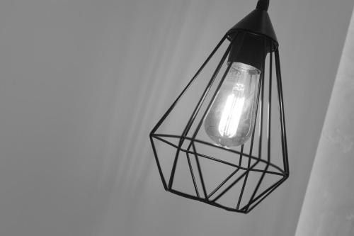 a black lantern light hanging from a wall at Horizon rooms in Torre Lapillo