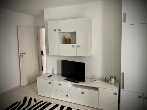 ein Wohnzimmer mit einem TV auf einem weißen Schrank in der Unterkunft CASA NADIA BRASOV in Braşov