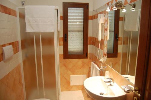 La salle de bains est pourvue d'un lavabo, de toilettes et d'un miroir. dans l'établissement B&B Il Corbezzolo, à Posada