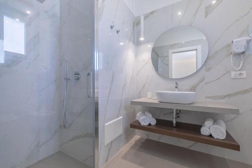 a white bathroom with a sink and a mirror at Horizon rooms in Torre Lapillo