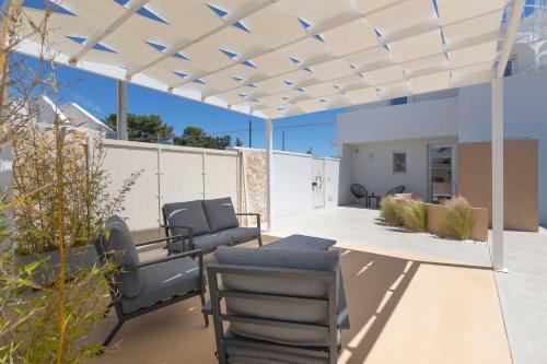 a patio with couches and chairs under a pergola at Horizon rooms in Torre Lapillo