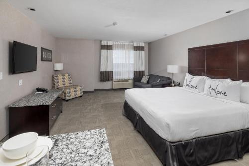 a hotel room with a large bed and a living room at Home Inn & Suites Yorkton in Yorkton