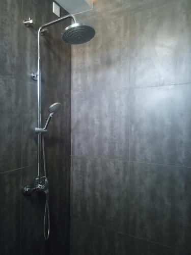 a shower with a shower head in a bathroom at Violet Inn Hotel in Dharavandhoo