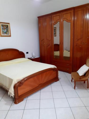 um quarto com uma cama, uma cómoda e uma cadeira em Casa Cesa em Selargius