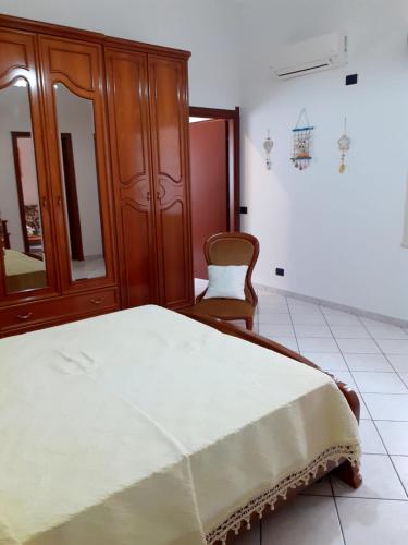 um quarto com uma cama e um armário de madeira em Casa Cesa em Selargius