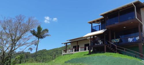 a building on a hill with a palm tree at Marques Home in Porto Belo